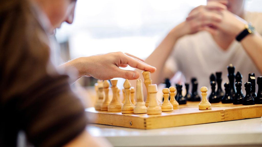 Kaksi henkilöä pelaa shakkia.