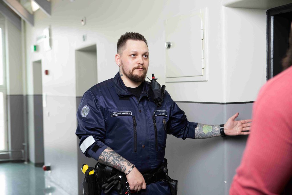Vartija ohjaa vangin selliin.