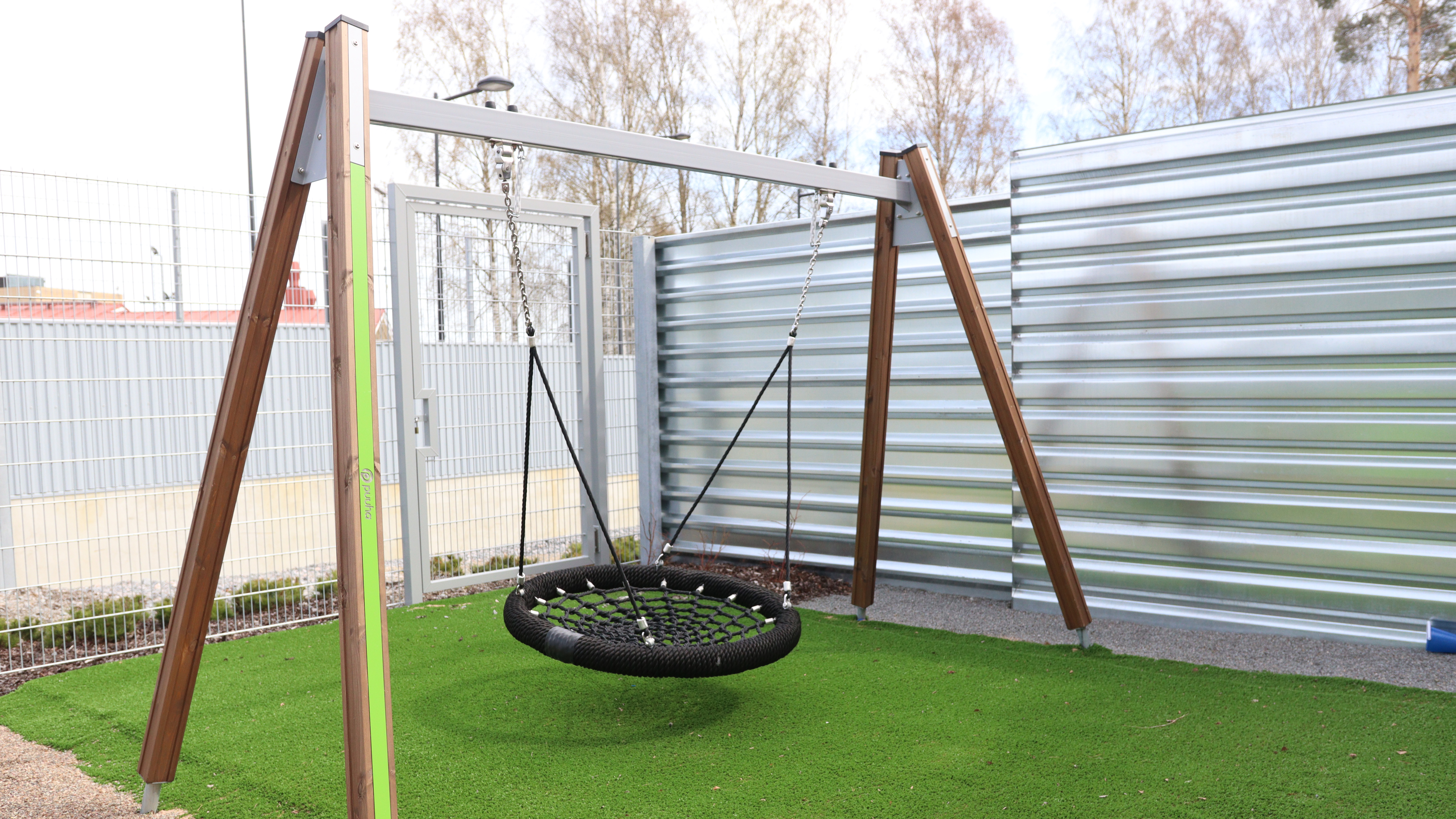 A bird’s nest swing is in a prison yard.